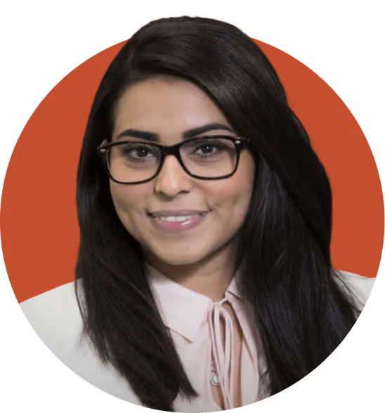 Smiling woman in glasses with long hair in front of an orange background.